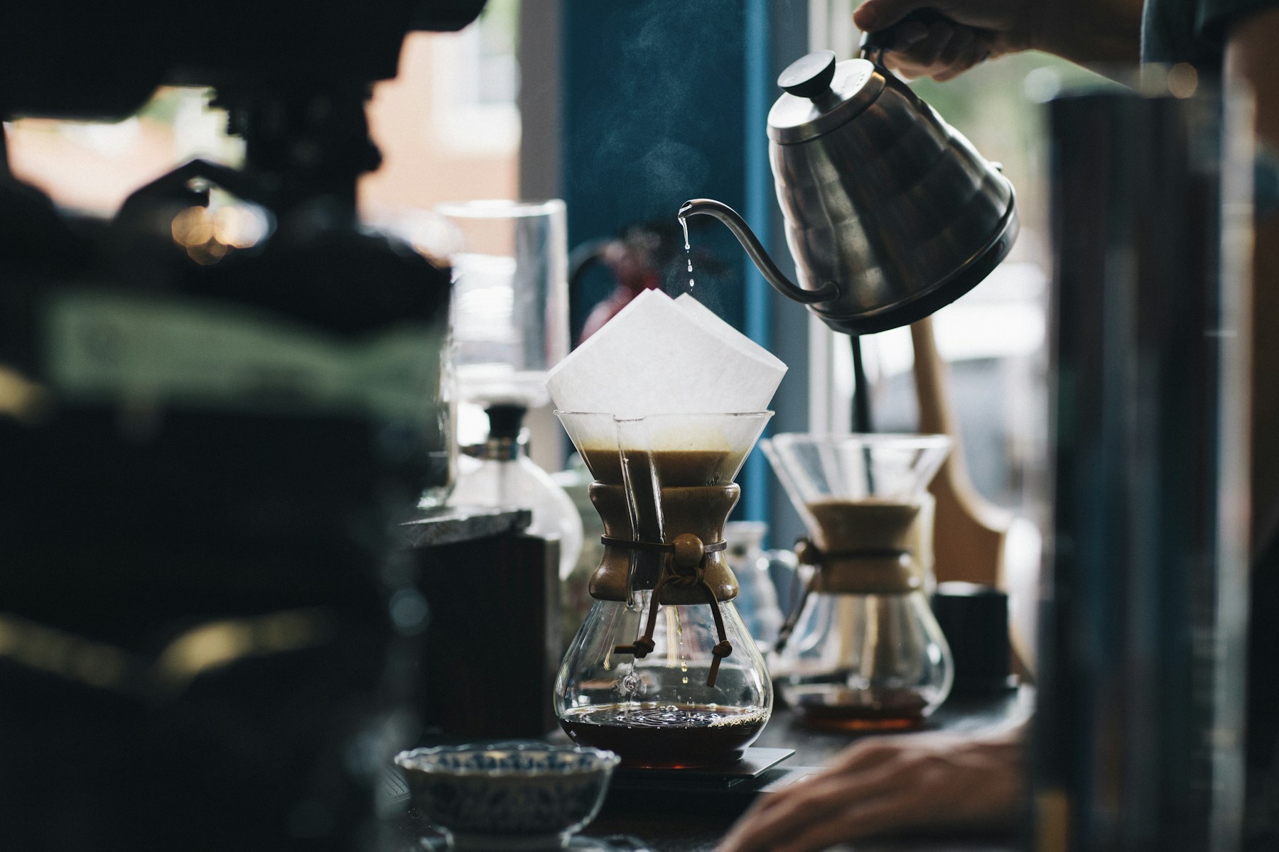 Coffee being poured through a filter into a glass carafe